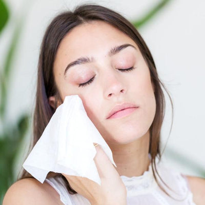 Beautiful girl using ogee gentle glow cleansing cloths to remove makeup and moisturize her face with jojoba oil